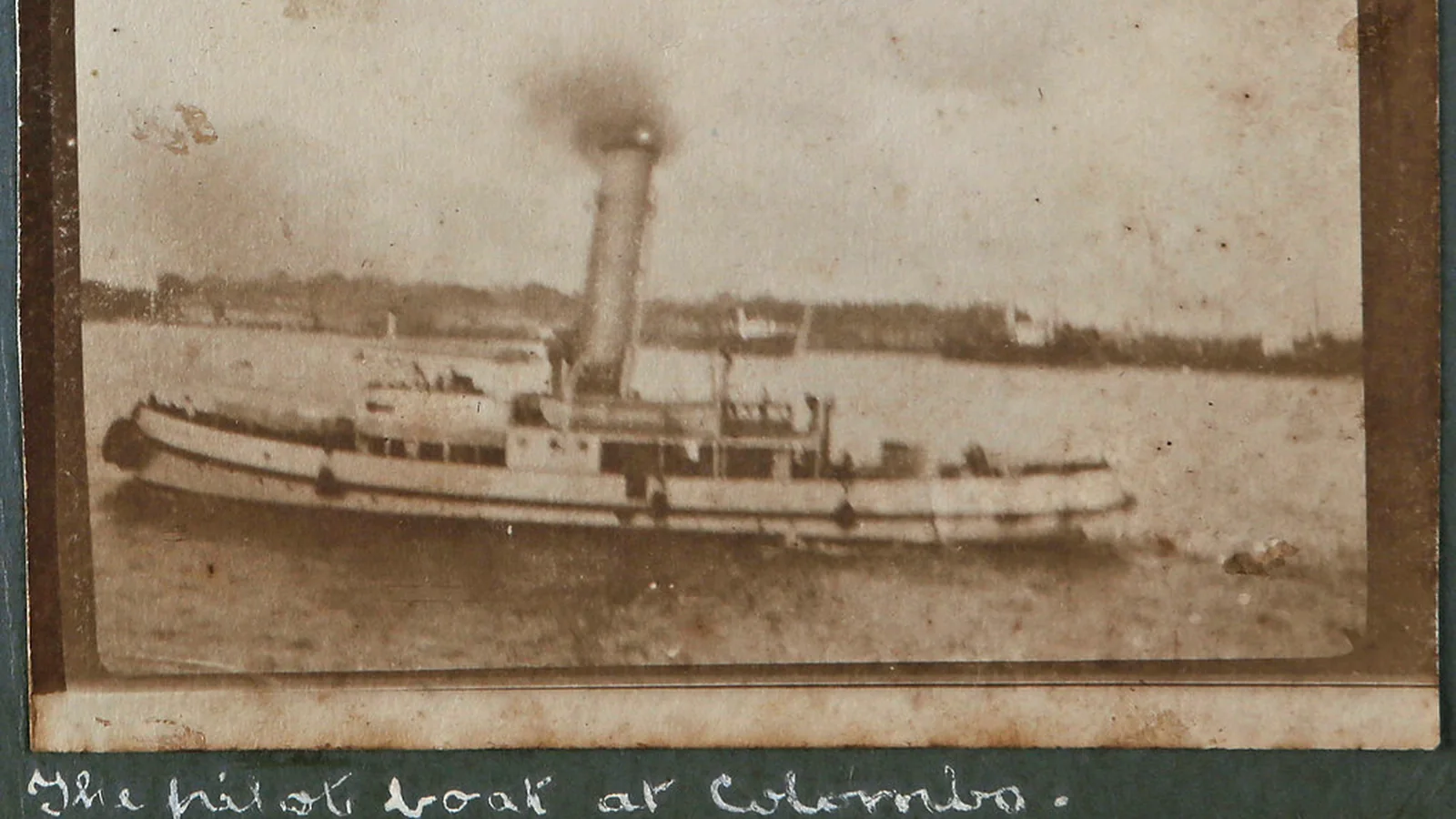 An old album photograph of a pilot boat with a handwritten caption underneath.